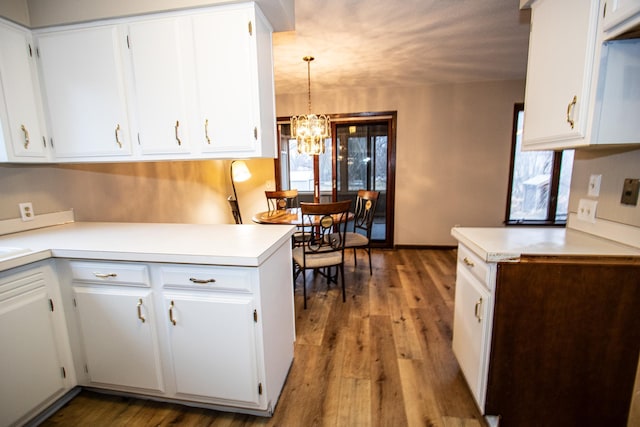 kitchen featuring white cabinets, dark hardwood / wood-style flooring, decorative light fixtures, and a chandelier