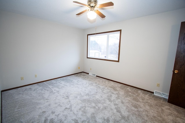 carpeted spare room featuring ceiling fan