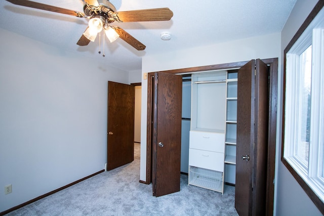 unfurnished bedroom featuring ceiling fan, a closet, and light carpet