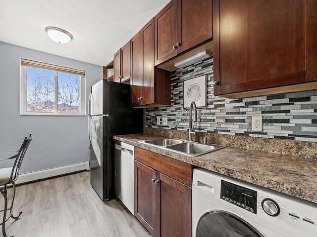 kitchen featuring washer / dryer, sink, backsplash, stainless steel dishwasher, and light wood-type flooring