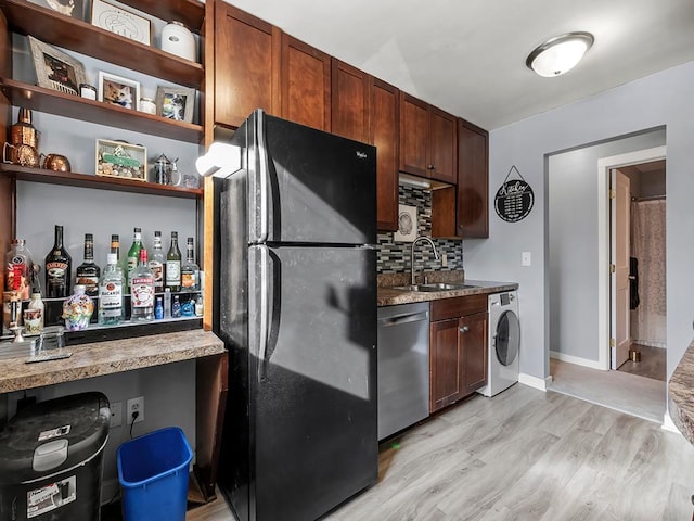 kitchen featuring washer / clothes dryer, dishwasher, sink, light hardwood / wood-style floors, and black fridge