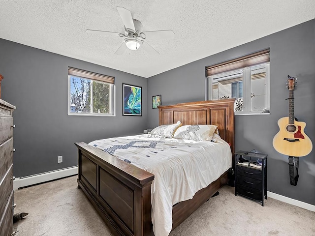 carpeted bedroom featuring ceiling fan, a textured ceiling, and a baseboard heating unit