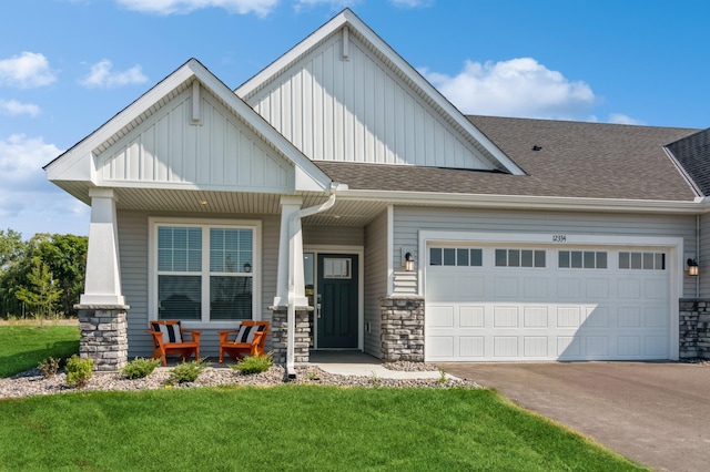 craftsman-style house featuring a garage, covered porch, and a front lawn