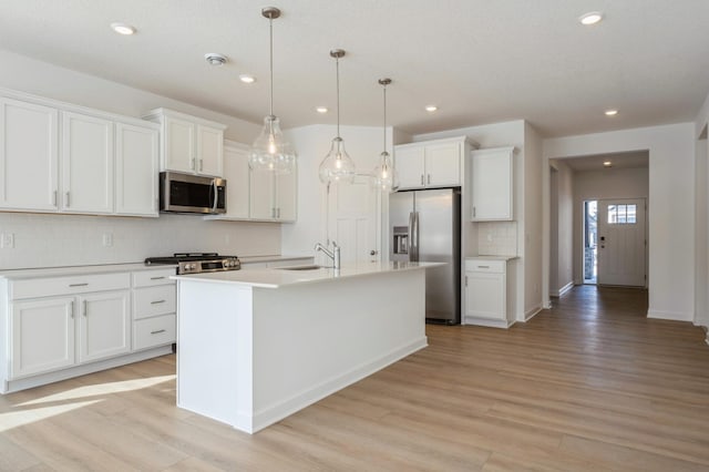 kitchen with white cabinetry, sink, a center island with sink, and appliances with stainless steel finishes