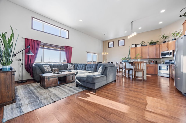 living room featuring light wood-type flooring and a towering ceiling