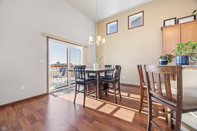 dining area with high vaulted ceiling, dark hardwood / wood-style flooring, and a chandelier