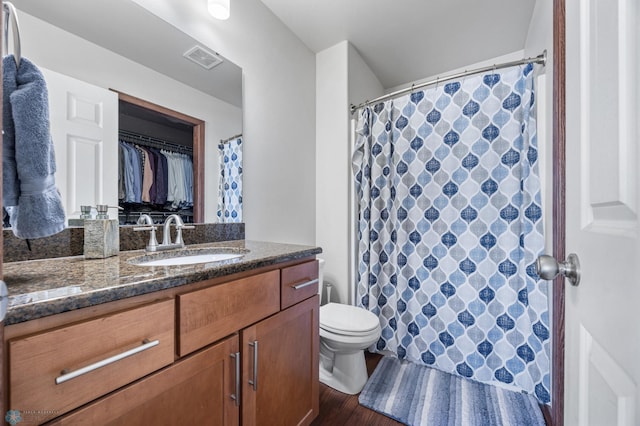 bathroom featuring toilet, hardwood / wood-style floors, and vanity