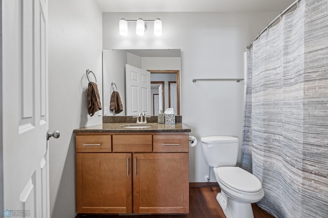 bathroom featuring toilet, wood-type flooring, and vanity