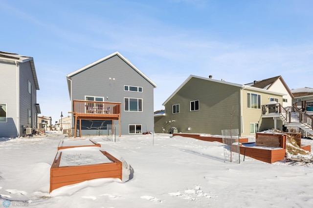 snow covered house featuring a deck