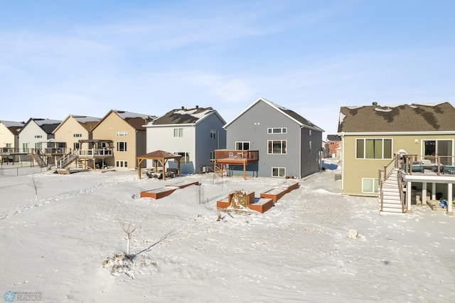 snow covered property with a gazebo and a wooden deck