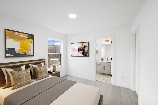 bedroom featuring light carpet, connected bathroom, and sink