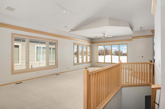 corridor featuring visible vents, baseboards, carpet, vaulted ceiling, and an upstairs landing