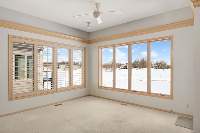 carpeted empty room with a ceiling fan, visible vents, and baseboards