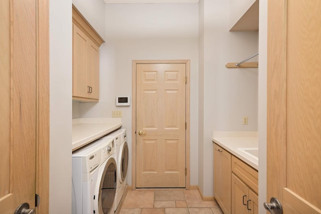 laundry room featuring baseboards, a sink, cabinet space, and washer and dryer