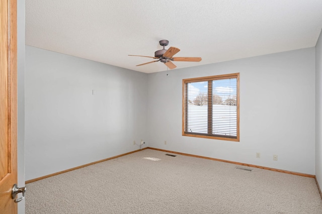 unfurnished room featuring baseboards, visible vents, ceiling fan, a textured ceiling, and carpet flooring