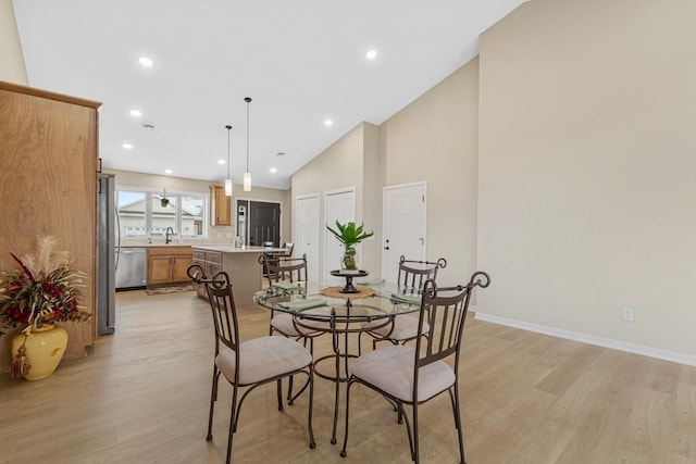2834 Meadowview Ln NE, Owatonna, MN 55060 - dining room with light wood-style flooring, baseboards, recessed lighting, and high vaulted ceiling
