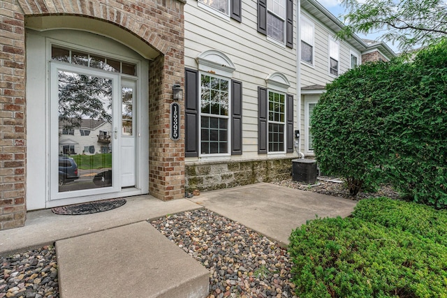 doorway to property featuring a patio and cooling unit