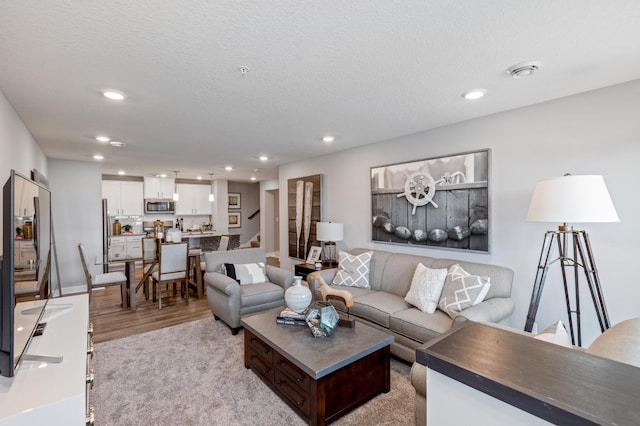 living room featuring a textured ceiling and light hardwood / wood-style flooring