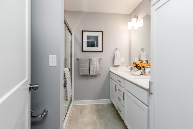 bathroom with vanity and a shower with door