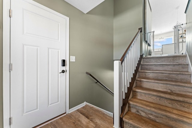 staircase with baseboards and wood finished floors