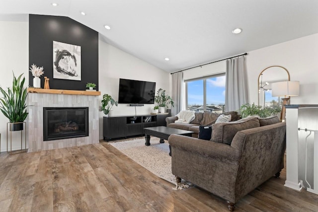 living area with high vaulted ceiling, recessed lighting, a fireplace, and wood finished floors