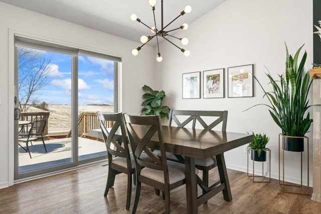 dining space featuring a notable chandelier, baseboards, and wood finished floors