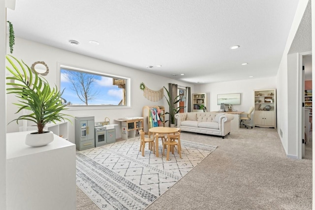 living area featuring a textured ceiling, plenty of natural light, and light colored carpet