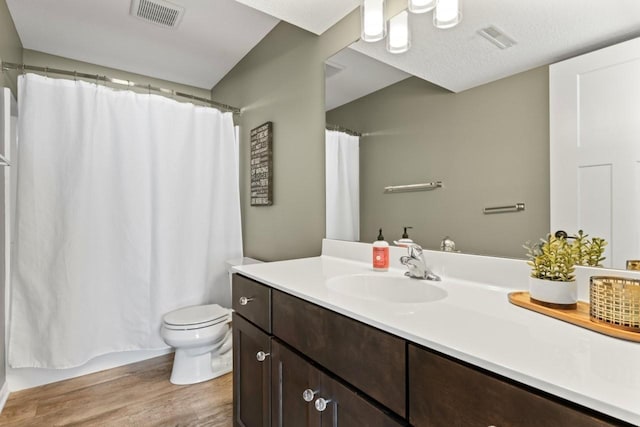 bathroom featuring toilet, visible vents, wood finished floors, and vanity