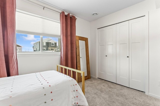 carpeted bedroom with baseboards and a closet