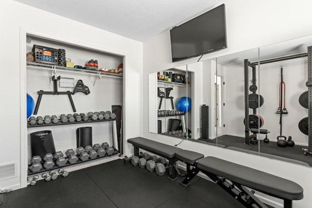 workout room featuring visible vents and a textured ceiling