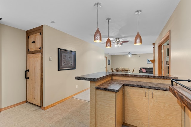 kitchen featuring light tile patterned floors, ceiling fan, hanging light fixtures, kitchen peninsula, and light brown cabinets