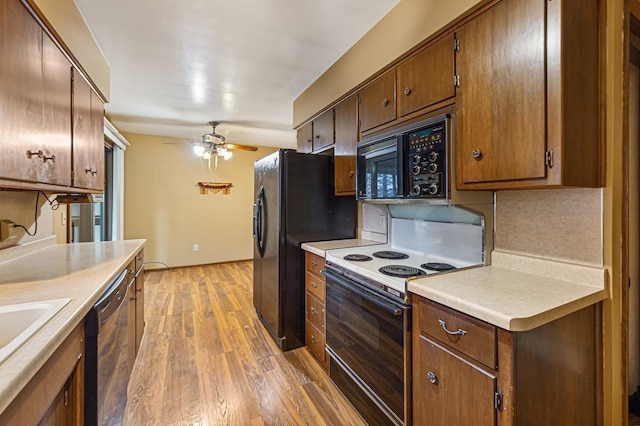 kitchen featuring dark hardwood / wood-style flooring, decorative backsplash, ceiling fan, and black appliances