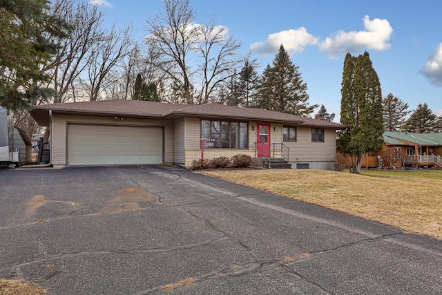 ranch-style house featuring a garage and a front lawn