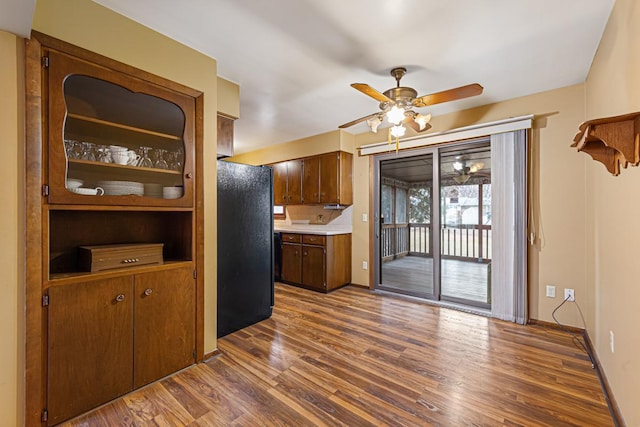 kitchen featuring black fridge, dark hardwood / wood-style flooring, and ceiling fan