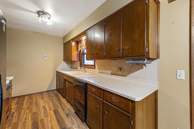 kitchen with dark wood-type flooring, dishwasher, backsplash, and sink