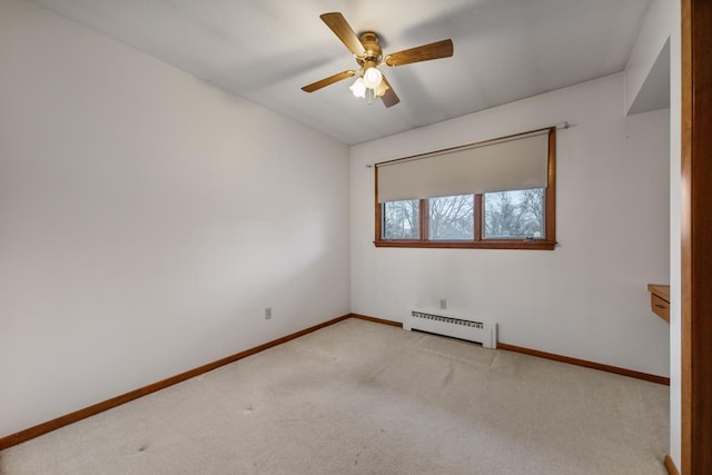 spare room featuring ceiling fan, a baseboard radiator, and light carpet