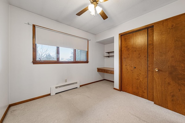 unfurnished bedroom featuring ceiling fan, baseboard heating, a closet, and light carpet