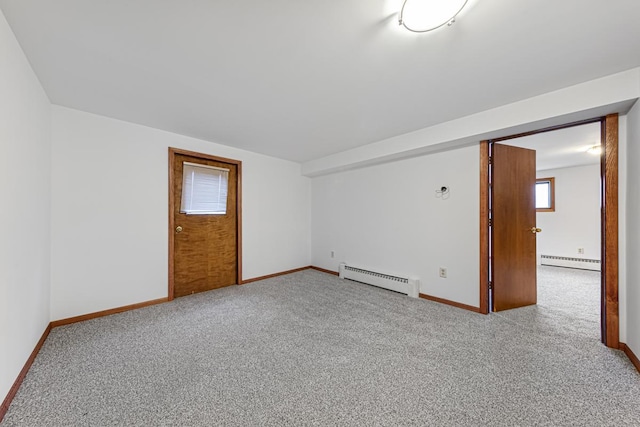 carpeted empty room featuring a baseboard heating unit