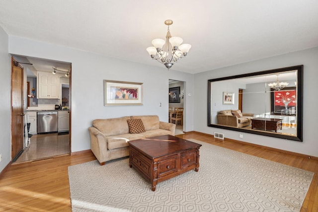 living room featuring light hardwood / wood-style flooring and a chandelier