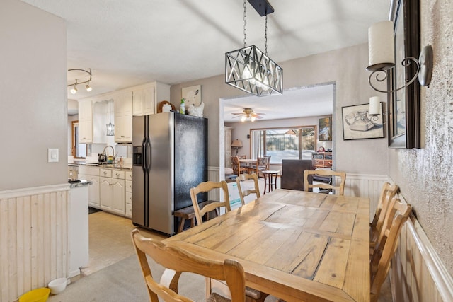 dining room with sink and ceiling fan with notable chandelier