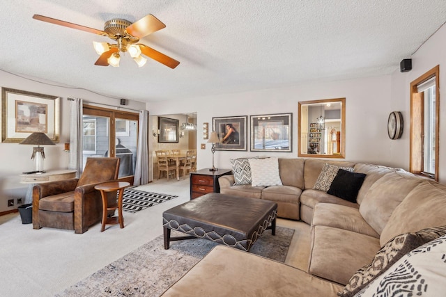 living room featuring light carpet, a textured ceiling, and ceiling fan