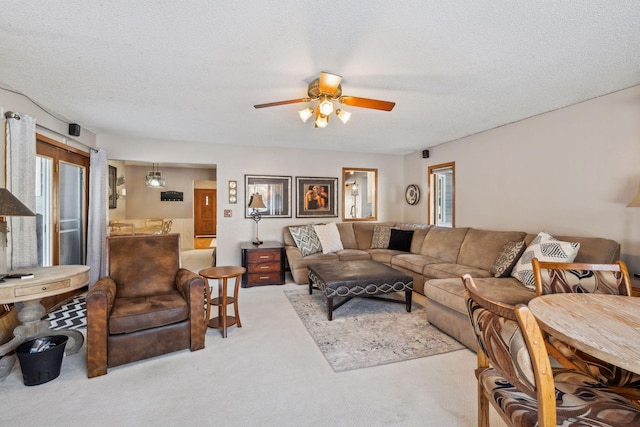 carpeted living room with a textured ceiling and ceiling fan