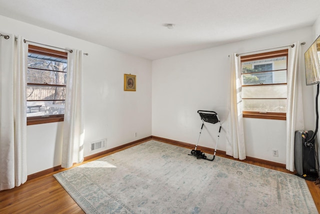 unfurnished room with hardwood / wood-style floors and plenty of natural light