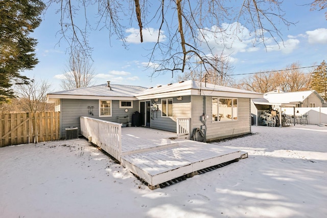 snow covered property with central AC and a deck