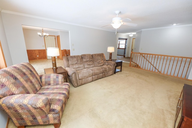 living room with crown molding, carpet, ceiling fan with notable chandelier, and wood walls