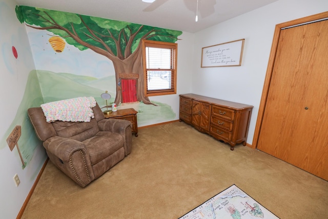 sitting room with ceiling fan and light colored carpet