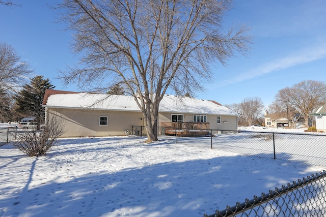 snow covered rear of property featuring a deck