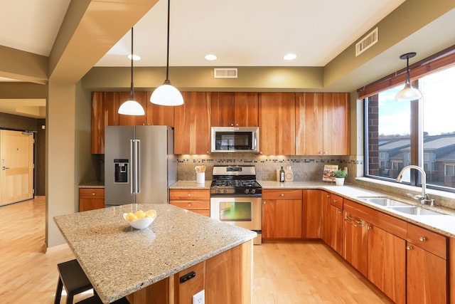 kitchen featuring appliances with stainless steel finishes, visible vents, a sink, and backsplash