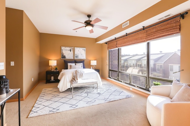 carpeted bedroom with a ceiling fan, visible vents, and baseboards