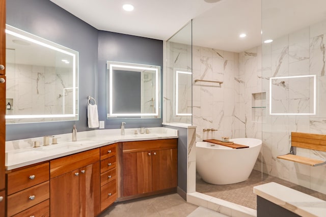 bathroom with recessed lighting, a freestanding tub, a sink, and double vanity